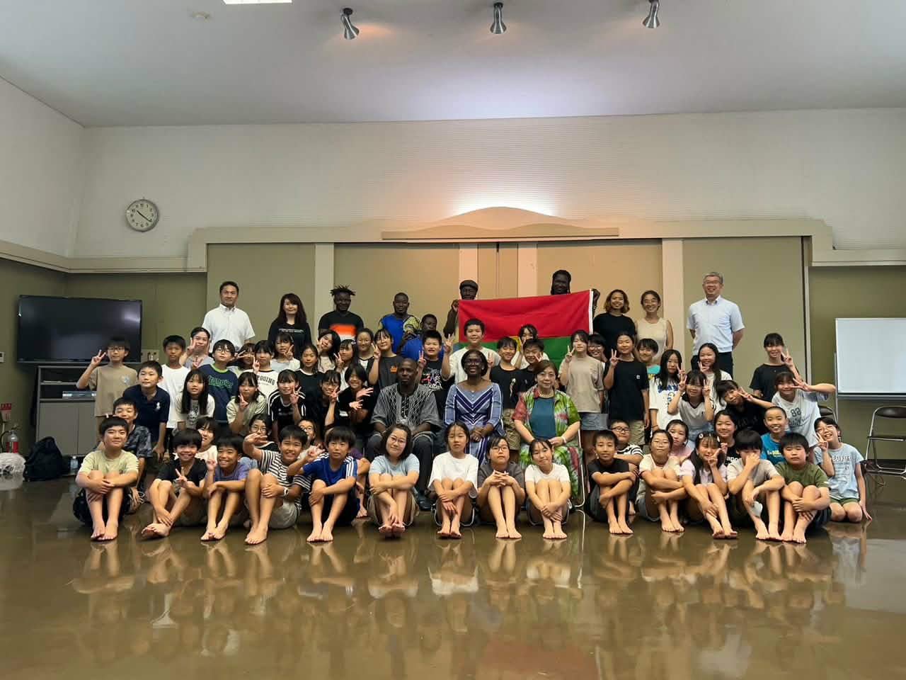 Musicians from Burkina Faso, Keiko Fujiie, and pupils of Kanahashi Primary School with the two national flags